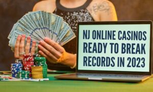 woman holding money behind poker chips and computer