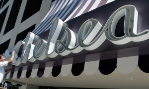 An employee shines the sign for the Chelsea Hotel, much like community members and incoming companies are investing in the Chelsea area of Atlantic City to help turn the neighborhood around.