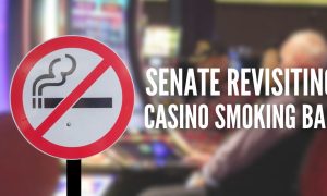 Man plays slots behind a no smoking sign for a story on the New Jersey Senate revisiting a smoking ban at Atlantic City casinos