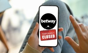 Image of a phone with the Betway Casino logo with a temporarily closed sign for a story on the operator shutting down March 11