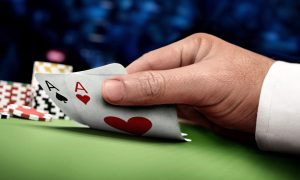 Image of a hand holding poker cards for a story on 888 expecting to shut down its online poker operations in New Jersey.