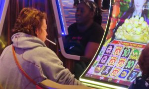 A customer smokes while playing slots at Hard Rock for a story on Caesars and Bally's shareholders opposing research of smoke-free casino floors.