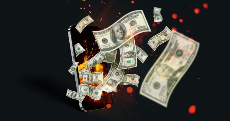 Image of a phone with dollar bills flying out for a story on the June 2024 revenue report for online casinos in New Jersey.