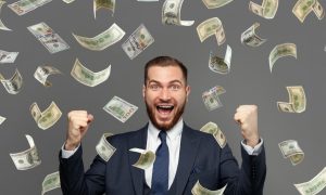Man raises his fist excitedly as money rains down on him. A BetMGM player in New Jersey cashed a progressive slot for $6.4 million earlier this week. It is the largest jackpot in iGaming history.