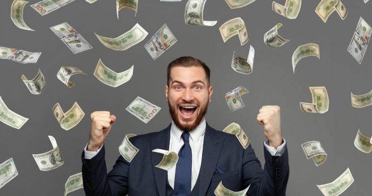 Man raises his fist excitedly as money rains down on him. A BetMGM player in New Jersey cashed a progressive slot for $6.4 million earlier this week. It is the largest jackpot in iGaming history.