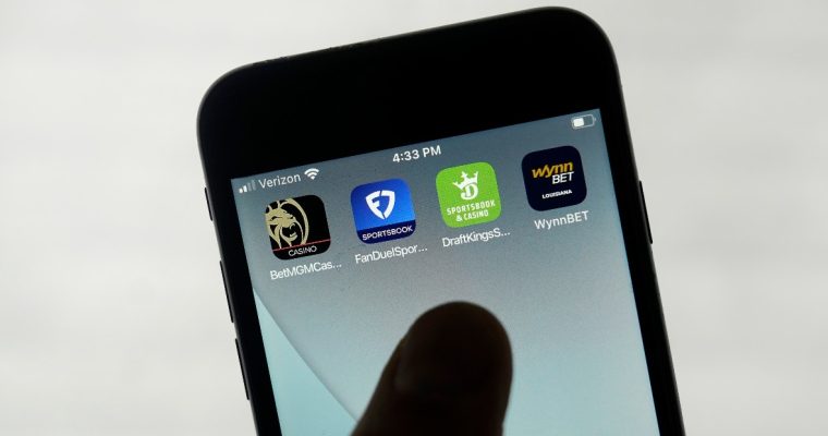 Phone with apps for BetMGM, FanDuel, DraftKings, and WynnBet
