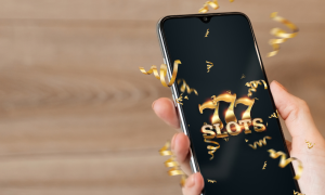 a hand holding a phone with 777 slots appearing on the screen