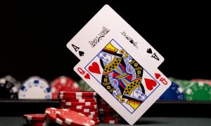 a blackjack hand next to piles of poker chips