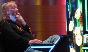 a man smokes while at a slot machine