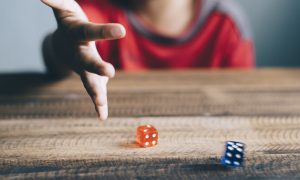 Young boy rolling dice underage gambling