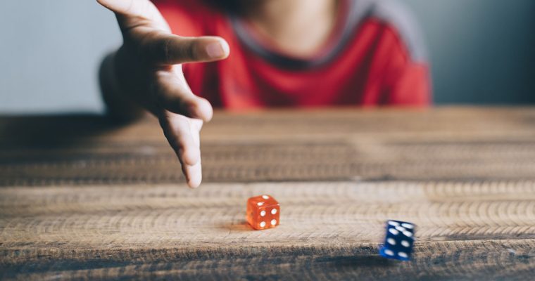 Young boy rolling dice underage gambling