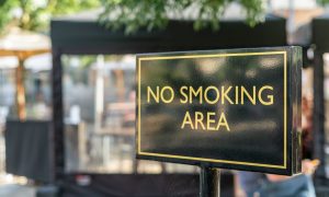 a no smoking sign in front of a public place