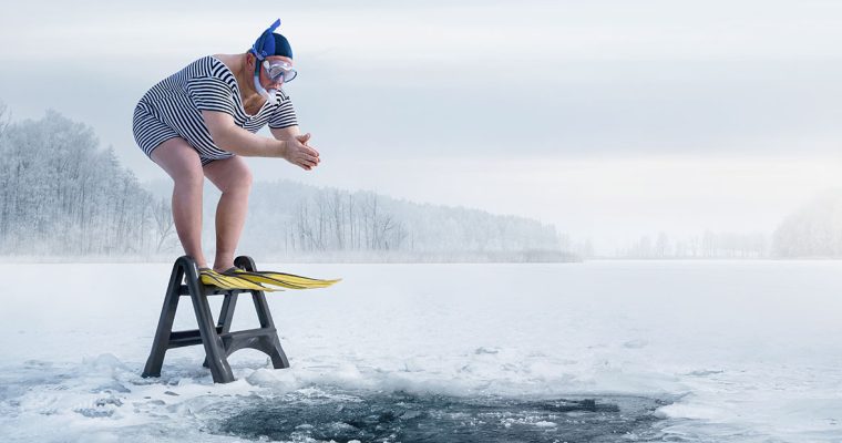Freezing cold winter day man prepares to dive into ice water