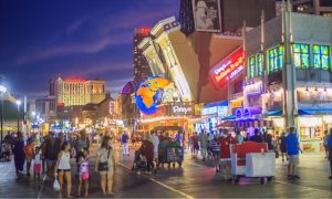 Crowds walk the Atlantic City Boardwalk at night near Ripley's Believe It or Not