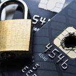 Padlock closing over a credit card with a burned chip