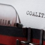 Typewriter page reading 'coalition,' representing the multistate AG letter to the CFTC