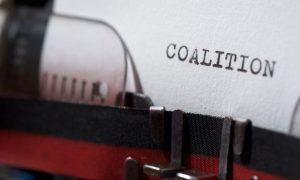 Typewriter page reading 'coalition,' representing the multistate AG letter to the CFTC