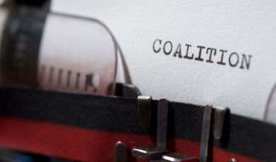 Typewriter page reading 'coalition,' representing the multistate AG letter to the CFTC