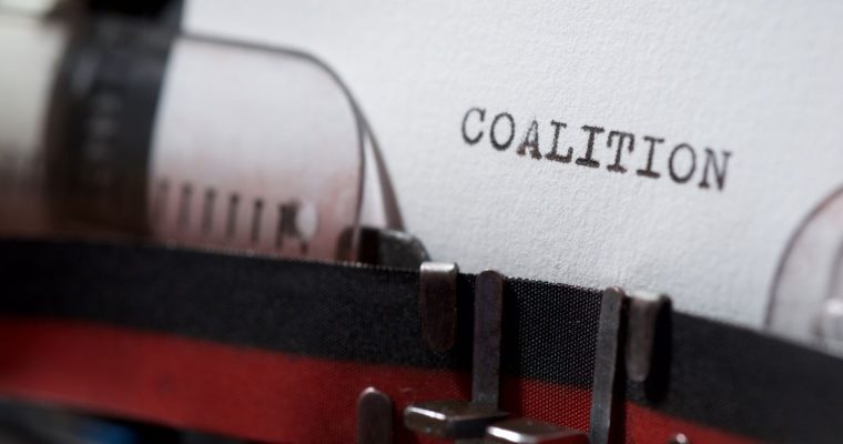 Typewriter page reading 'coalition,' representing the multistate AG letter to the CFTC
